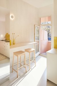 Na originálně zpracovaný botník plynule navazuje barový stůl. (Byt pro malířku v Praze-Holešovicích od Plus One Architects)