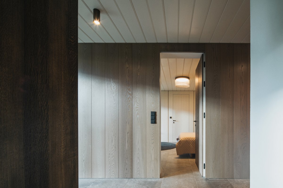 Interiér využívá sjednocenou materiálovou paletu a střídmé detaily, které podporují klidnou atmosféru horského domu. (Chalupa ve stráni; Mimosa Architekti)