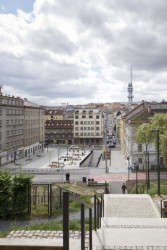 Náměstí lemuje cyklostezka, rušná ulice Hartigova (bývalá Koněvova) a činžovní domy s živým parterem. (Tachovské náměstí v Praze, OVA)