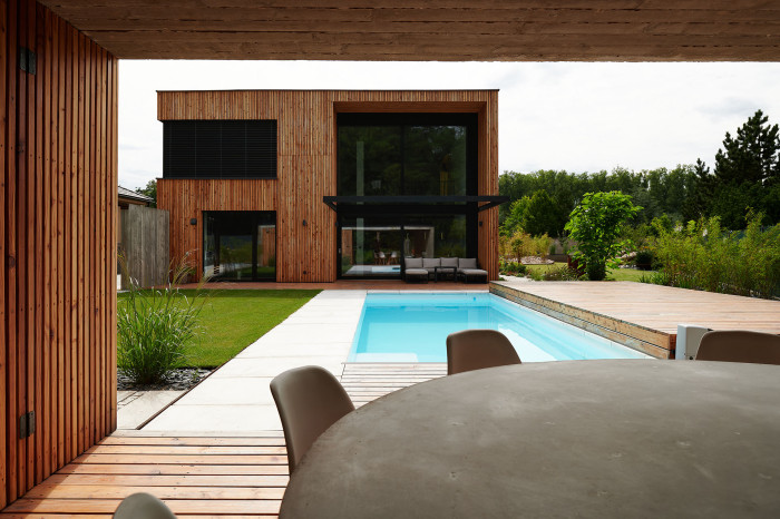 Na kuchyň, obývací pokoj a jídelnu navazuje intimnější část zahrady s bazénem. (Dům ve třech zahradách, Air ateliér)