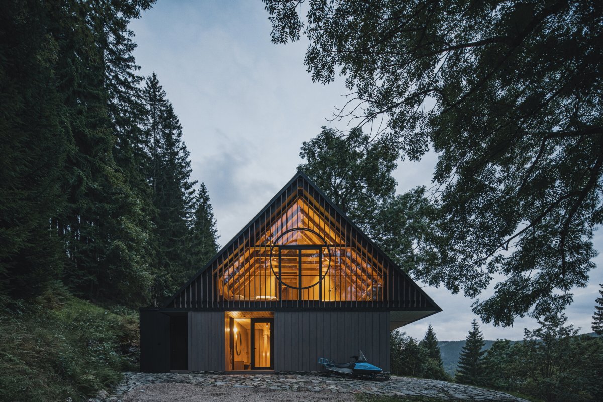 Večerní pohled zdůrazňuje otevřenost podkroví a propojení interiéru s okolní krkonošskou krajinou. (Chalupa ve stráni; Mimosa Architekti)