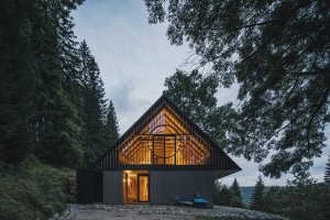 Večerní pohled zdůrazňuje otevřenost podkroví a propojení interiéru s okolní krkonošskou krajinou. (Chalupa ve stráni; Mimosa Architekti)