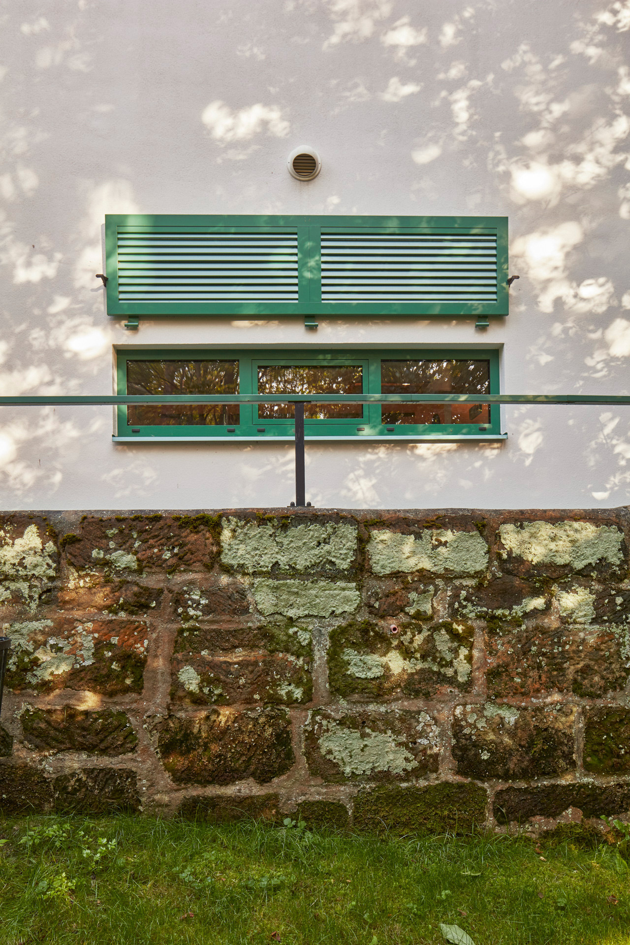 Při rekonstrukci mu zůstal jeho původní tvar i bílá omítka, přibyly zelené detaily. (Rodinný dům Chřibská od 0,5 Studio)