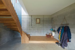 Betonová „noha“ v přízemním patře slouží jako vstupní hala se schodištěm a šatnou. (Rodinný dům v Řevnicích, 0,5 studio)