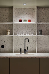 Pracovní plocha, obklad a police byly vyrobeny na míru ze světlého terrazza. 