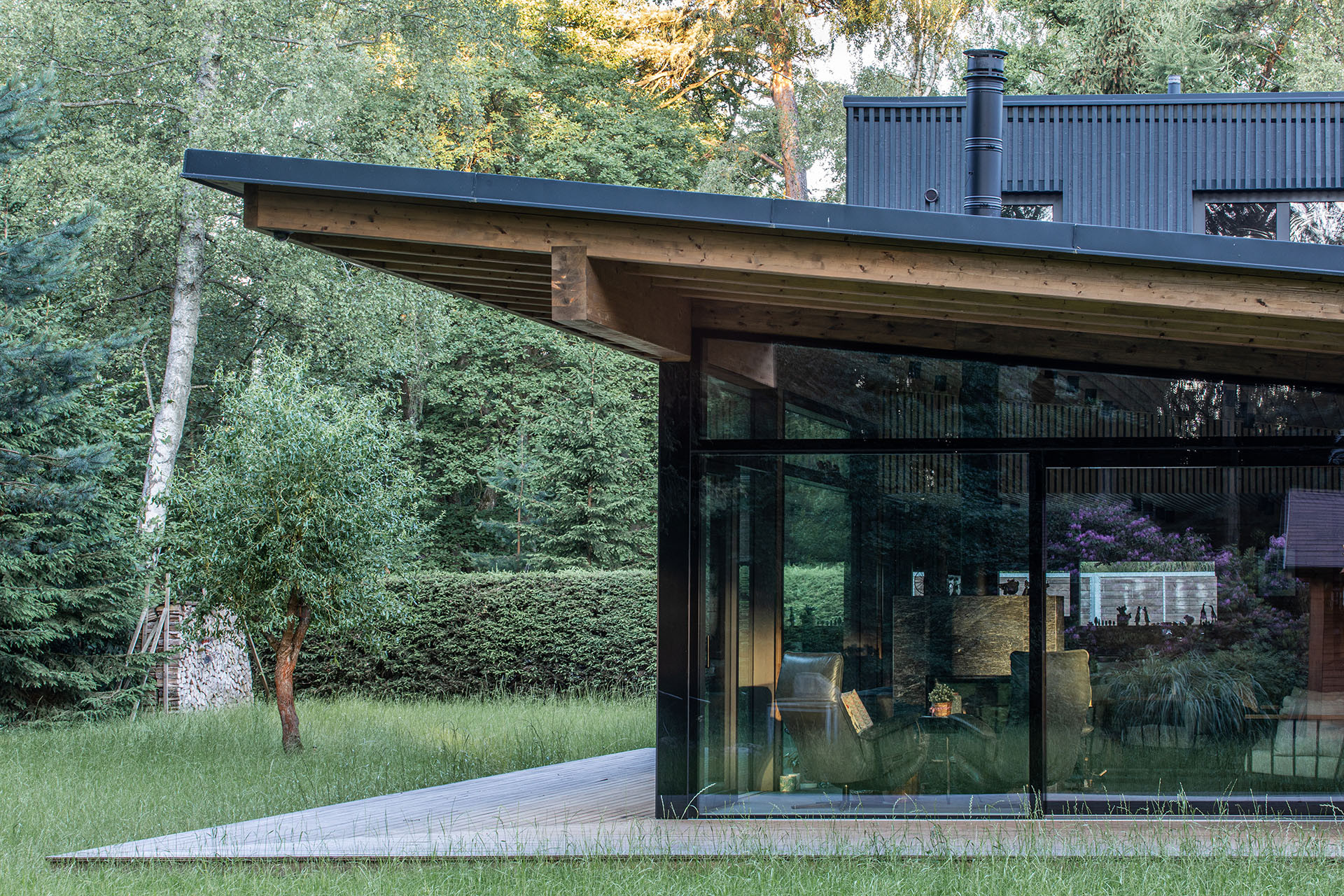 Roubený dům s velkým prosklením a vloženou kostkou. Netradiční řešení od studia monom.