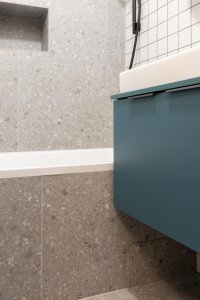 Terrazzová dlažba se propisuje i na obklad vany a stěny za ní. - Rekonstrukce bytu v Praze - Holešovicích, Studio Schwestern.