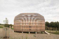 Kaple je vzdušná a průchozí, rámuje vchod do celého agrovoltaického areálu.