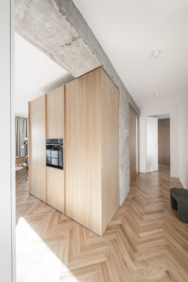 Dřevěná podlaha kladená do stromku sjednocuje obytný prostor. (Rekonstrukce bratislavského panelového bytu; Abrama architekti)