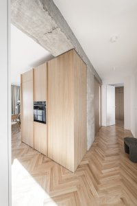 Dřevěná podlaha kladená do stromku sjednocuje obytný prostor. (Rekonstrukce bratislavského panelového bytu; Abrama architekti)