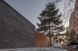 Navazuje na něj dřevěný plot, který dětské hřiště a přilehlý zatravněný plac cloní od okolních paneláků. (Vnitroblok Manětínská v Plzni, Sporadical)