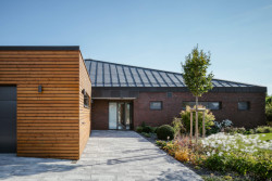 Cihelné zdivo se tu kombinuje s dřevěnou fasádou garáže.