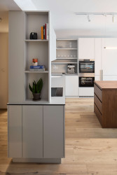 Kuchyně obsahuje samostatný kávový kout s podsvícenými policemi. (Interiér bytu Karlín; PANIKHORN)