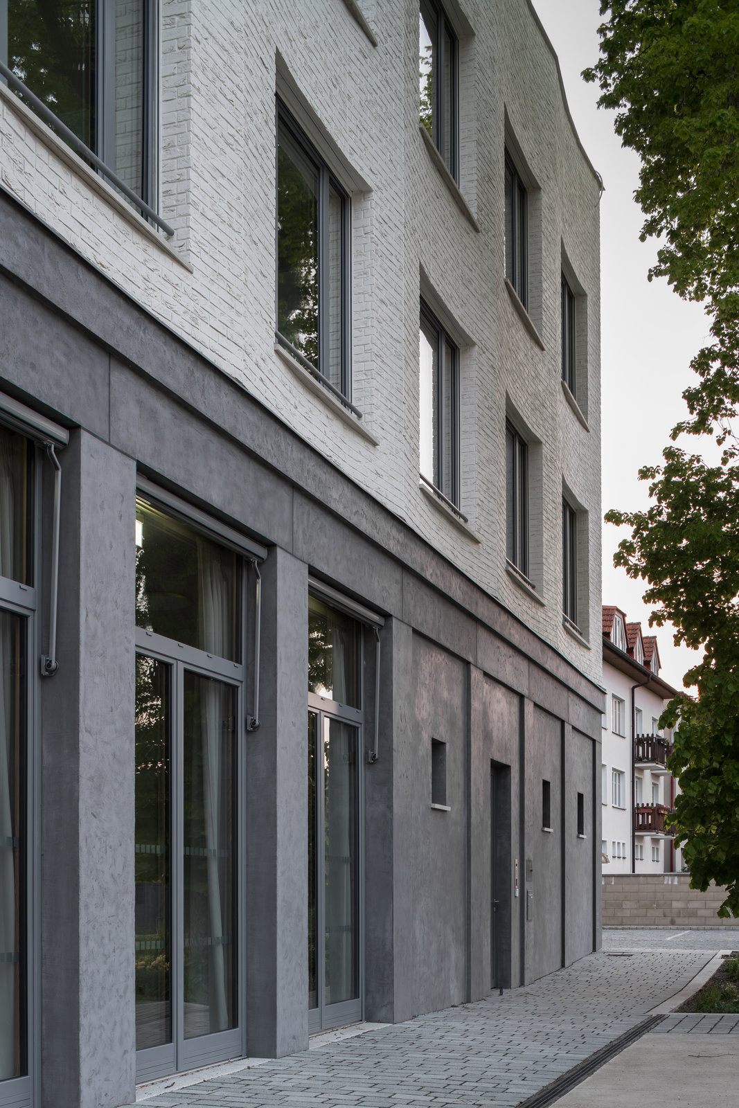 Plastická modelace fasády zvýrazňuje rytmus ploch a práci
s hloubkou bez nutnosti výrazných materiálových kontrastů. (Nová radnice s plastickou fasádou; re:architekti)