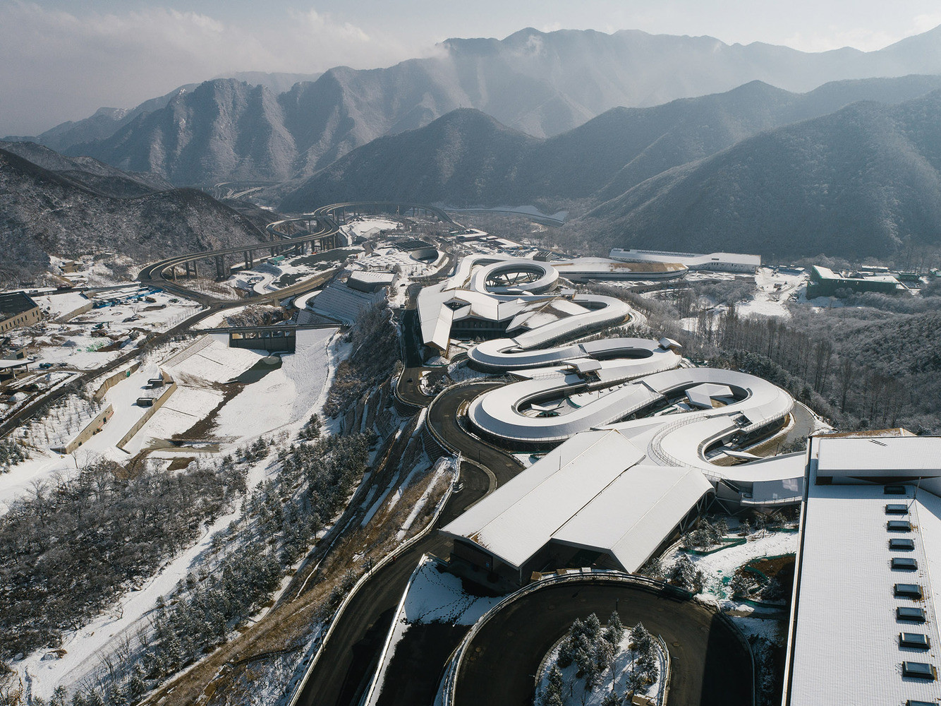Jako had kroutící se kopcovitou krajinou severně od Pekingu působí zbrusu nová aréna zasvěcená jízdě na bobech a skeletonu – jde o vůbec první takové sportoviště v celé Asii.