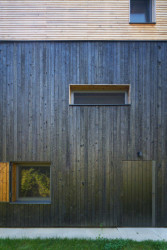 Novostavba má fasádu ze dřeva, kde se kombinují pálená prkna a přírodní dřevěné latě. To jí dodává vlídný a důvěrně známý „chatařský“ výraz. (Chata v Posázaví, Studio Sporadical)