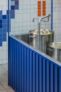 Detail pultu propojeného s otevřenou kuchyní (Bistro Ramencraft v Praze, SAO Architekti)