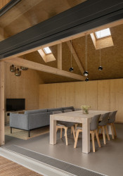 Uvnitř je obývací pokoj s kuchyní a jídelním stolem. (Víkendový dům v Českém ráji, NEW HOW Architekti)