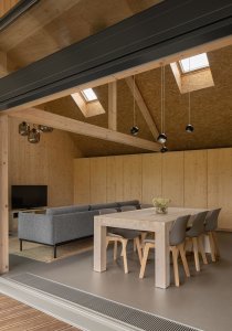 Uvnitř je obývací pokoj s kuchyní a jídelním stolem. (Víkendový dům v Českém ráji, NEW HOW Architekti)