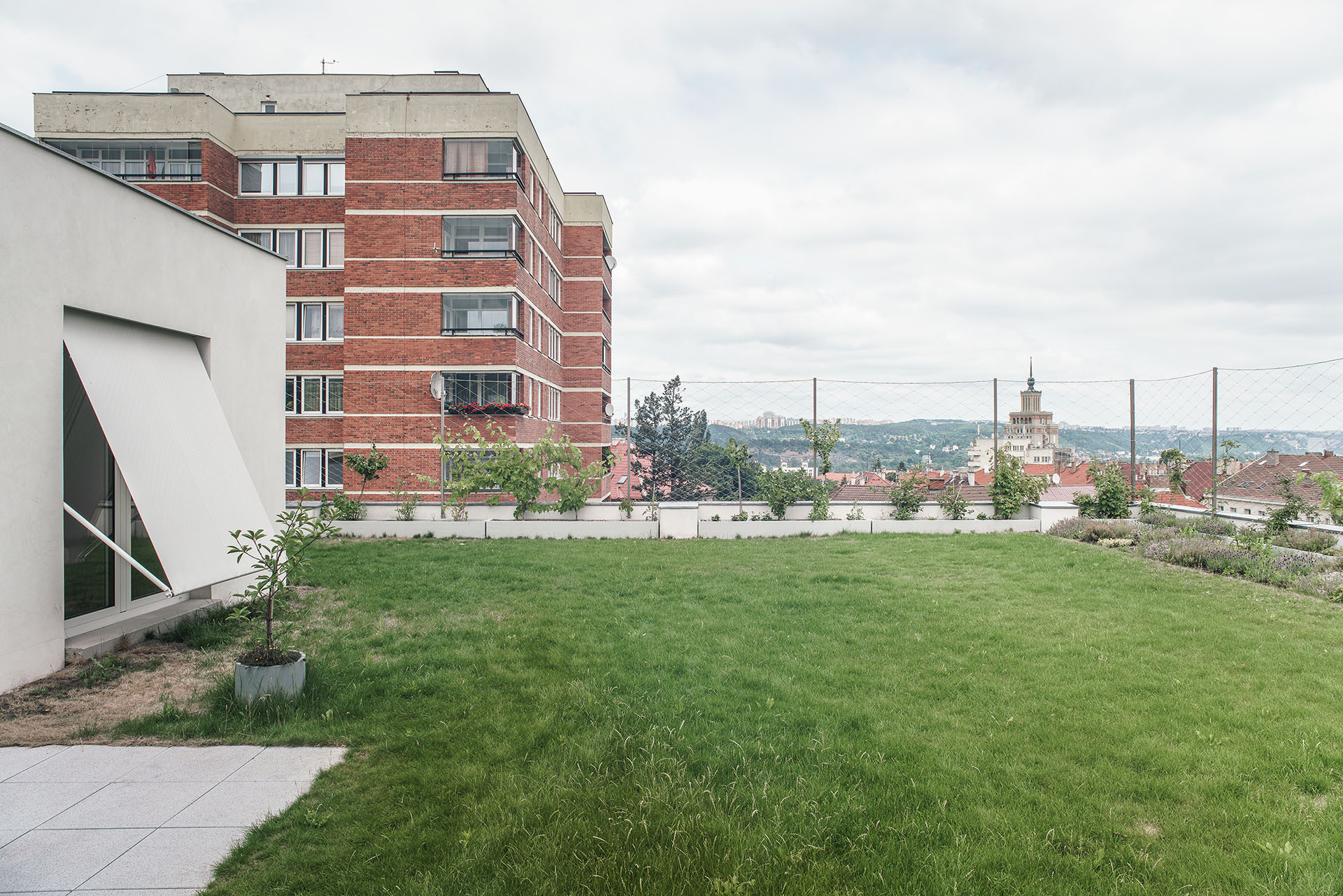 Na střeše bývalého obchodního střediska. Teď je tu trávník a bydlení. (Nástavba se zahradou v Praze-Dejvicích, Nácházel architekti)