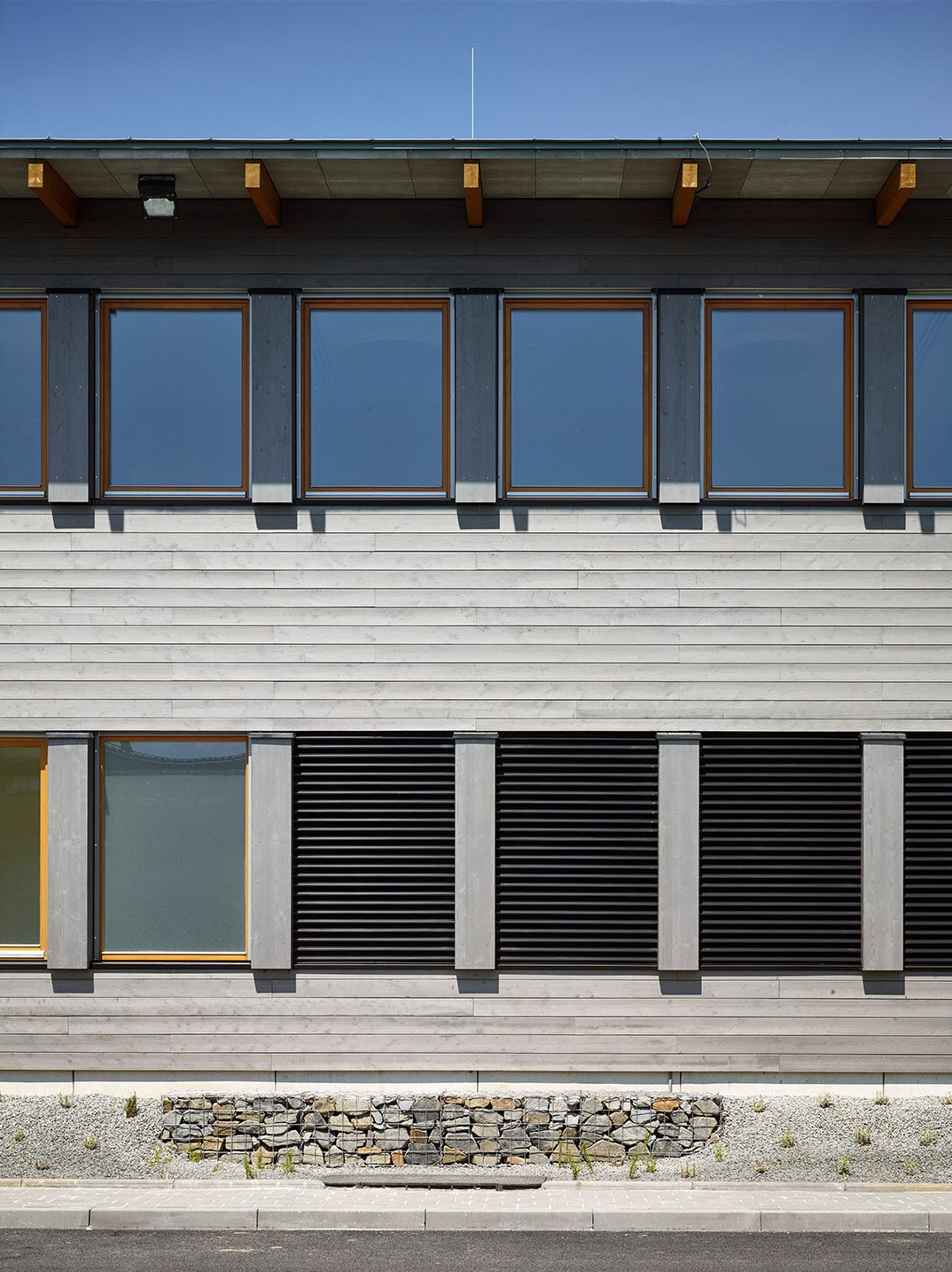 Dvoupodlažní budova s kancelářemi a zázemím pro zaměstnance má fasádu ze dřeva a nápaditý interiér. - Středisko správy a údržby dálnice, Přerov, Pelčák a partner architekti