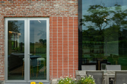 Nový otvor přibyl i na zadní fasádu domu. Dvoukřídlé prosklené okno se otevírá do zahrady. 