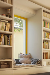 Stěny obývacího pokoje obalila knihovna s integrovaným posezením u okna. (Rekonstrukce prvorepublikového domu v údolí, 0,5 Studio)