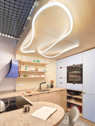 Ke kuchyňské lince se připojuje ostrůvek, který se využívá také jako jídelní stůl nebo k práci. (Bydlení na 37 metrech čtverečních; hurá studio)