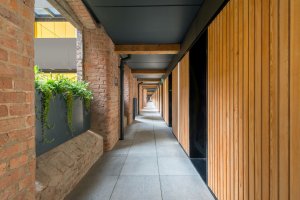 Byty jsou propojeny vnějšími pavlačemi. (Projekt Crusader Works: Přádelny v centru Manchesteru přestavěné na bydlení, studio shedkm)