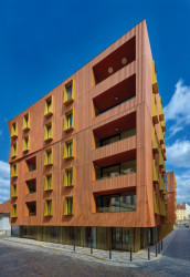 Rastr fasády se v jednotlivých patrech proměňuje – v přízemí je jemnější, směrem vzhůru hrubší. (Rezidence U Milosrdných na Starém Městě od Fránek Architects)