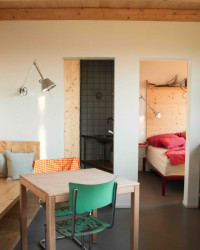 Obývací pokoj dále pokračuje do dvou místností. Napravo je ložnice.