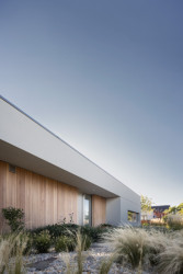 Rodinný dům je světle omítnut, místy bylo použito dřevěné obložení