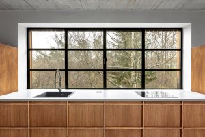 V interiéru se mísí bílá barva se dřevem a betonem. (Chata JARO u Prahy, edit! architects) 