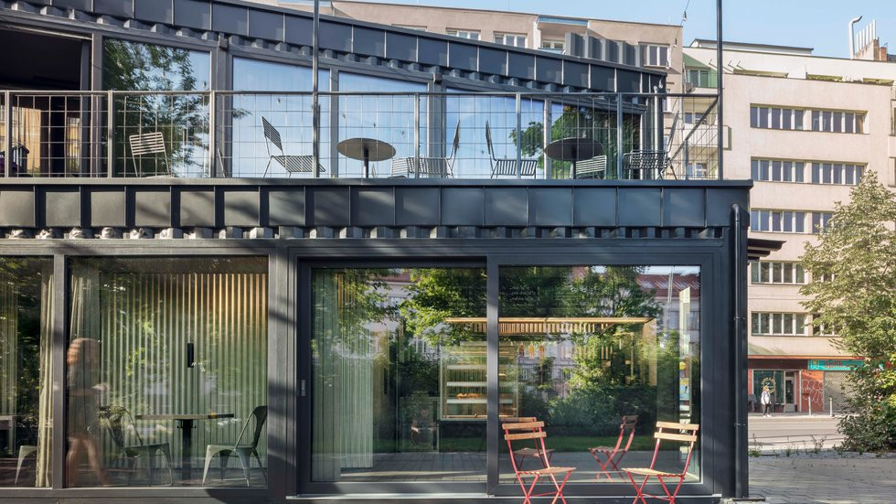 V srdci Prahy 7 na Ortenově náměstí vyrosla (dočasná) stavba z recyklovaných lodních kontejnerů, kavárna Kontejner. Svou hrubou industriální estetikou odkazuje k průmyslové historii Holešovic. COLLARCH, realizace 2021