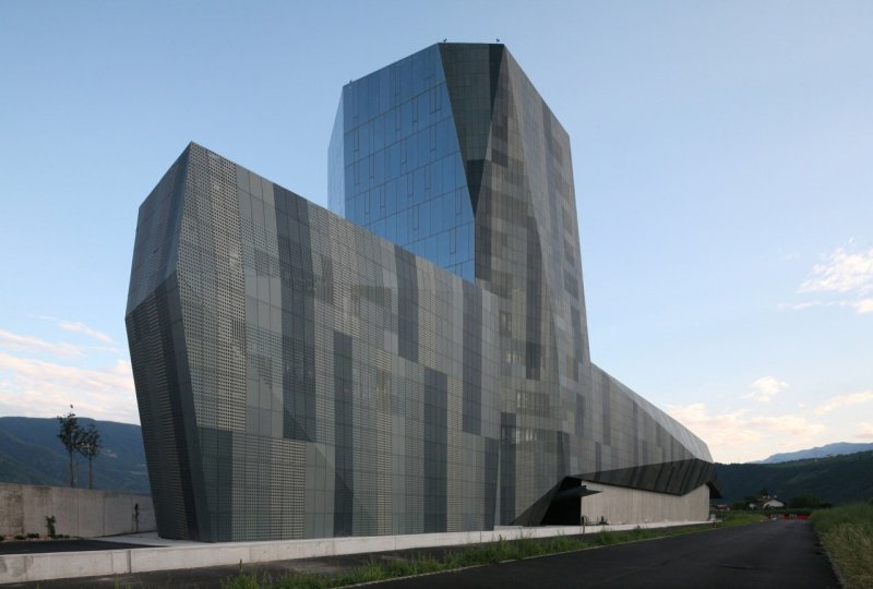 Na předměstí pak stojí kancelářská budova Salewa Headquatres, která z dálky působí jako Titanic.