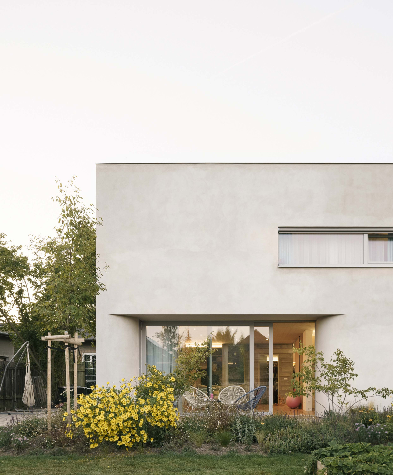 Přízemí se otevírá do zahrady velikými okny, které jsou umístěny na všechny světové strany. (Rodinný dům v Radotíně, Papundekl architekti)