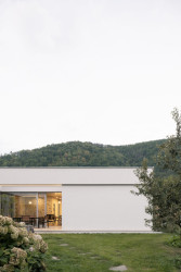 Architekt Ivo Stejskal ze studia AOSI navrhl rodinný dům v Nedvědicích s plochou vegetační střechou a bíle omítnutými obvodovými zdmi. (Dům s atrii v Nedvědicích, AOSI)