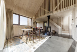 Když vstoupíte do domku, ocitnete se v přízemí. To tvoří hlavně obývací pokoj spojený s kuchyní. (Chata v Kořenově, Facha architekti)