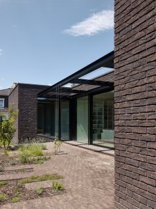 Z obývacího pokoje se dá vystoupit ven do poloatria a pak dál do zahrady. (Rodinný dům v Řepích, Stempel & Tesař architekti)
