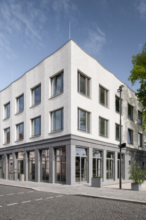 Detail vztahu budovy k náměstí - objekt působí jako přirozený organizující prvek veřejného prostoru. (Nová radnice s plastickou fasádou; re:architekti)