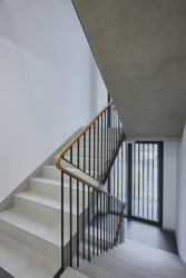 Atypické madlo zábradlí je vyrobeno z ohýbaného dřeva. (Bytový dům Krušec, monom)