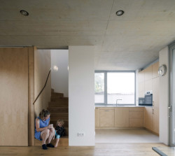 Schodišťový prostor je oddělitelný posuvnými dveřmi od obývacího pokoje. (Rodinný dům v Radotíně, Papundekl architekti)