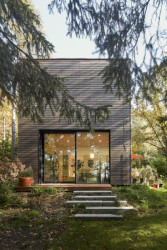 Vyšší hmota obsahuje mimo jiné obývací pokoj, okna má orientovaná do zeleně. (Dům v Davli, 0,5 Studio)