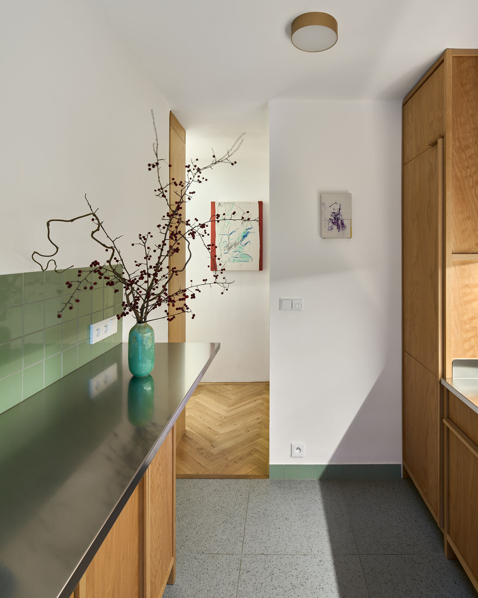 Na uvolněné straně kuchyně vznikl zvýšený barový pult, u kterého je možné sedět ve dvou až třech lidech. (Rekonstrukce bytu ve Vršovicích, Amulet architekti)