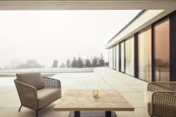 Kryté posezení s výhledem na bazén a krajinu propojuje interiér s exteriérem a podtrhuje klidnou atmosféru domu. (Bungalov ve východních Čechách; Atelier Kunc)