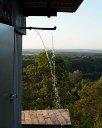 Otočením červeného kohoutu se schladíte v nevšední venkovní sprše – voda protéká podlahou z pororoštu rovnou do zahrady. 