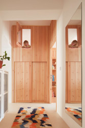 Kumbál na věci a nad ním okénko z dětského pokoje. (Plus One Architects, byt ve Vršovicích)