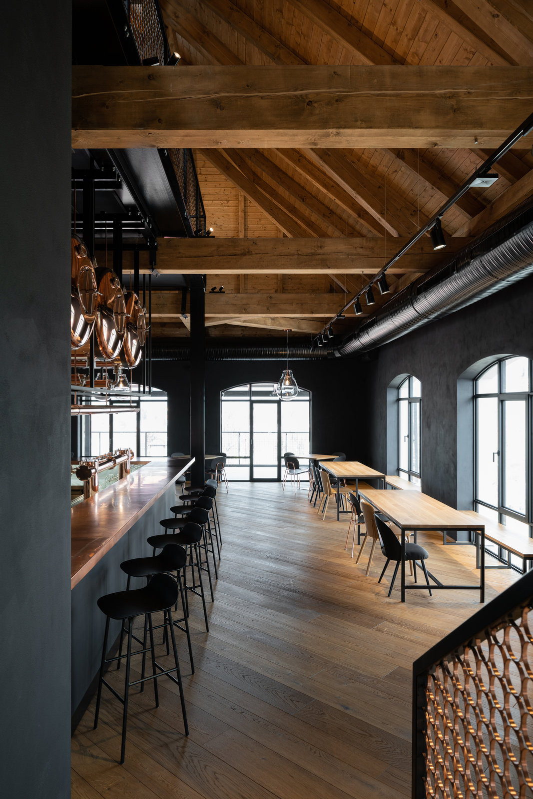 Úprava lehce kouřeného dubu dodává podlaze přirozeně tmavší odstín a zvýrazňuje kresbu dřeva. (Interiér pivnice Bernard v Humpolci; B² Architecture)