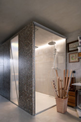 Papundekl architekti - Tři boxy z Packwallu v otevřeném prostoru: Box s prosklenou stěnou obsahující sprchový kout