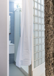 Luxferami do koupelny proniká přirozené světlo. (Rekonstrukce bytu v panelovém domě v Praze na Gutovce; P2P.)